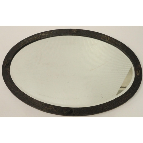 396 - Arts & Crafts hammered brass oval wall mirror with applied appliques, 58cm x 83cm.