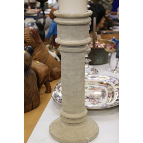 166 - Large heavy plaster turned candle holder of church style with large wax candle, 90cm high.