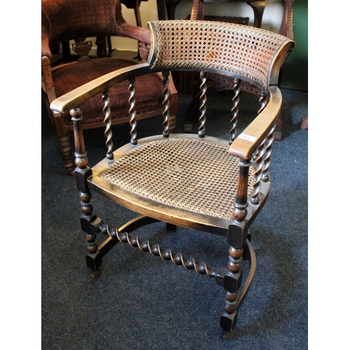 664 - Early 20th century oak tub chair with bergere seat and back rest, raised on turned supports.