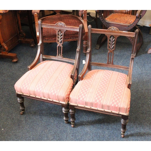 666 - Pair of late Victorian mahogany low chairs raised on turned and fluted supports capped by castors.