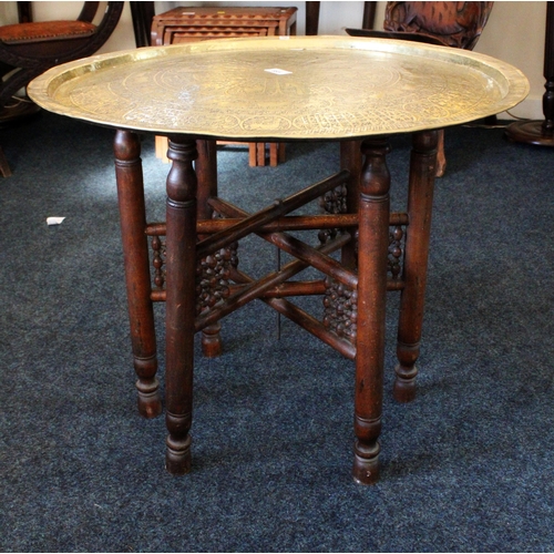 685 - Indian Benares brass charger top table on folding stand, 64cm diameter.