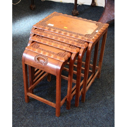 690 - Indian hardwood nest of four tea tables with carved designs of flowers, 43cm wide.