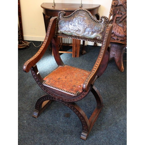 691 - Antique oak Savonarola armchair with leather back rest and seat pad raised on x-frame.