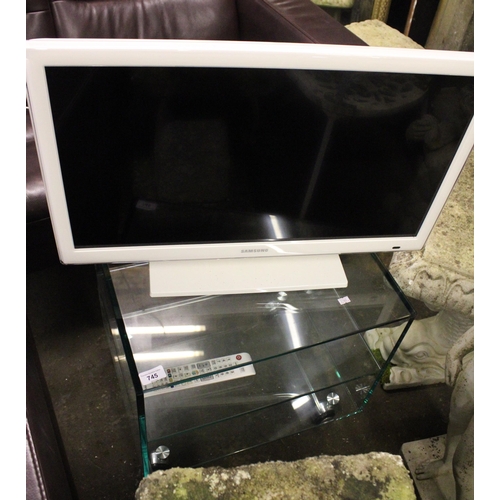 745 - Glass side table on castors and a Samsung television.