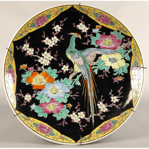 214 - Japanese porcelain charger, black ground with bird and foliate decoration, 46cm diameter.