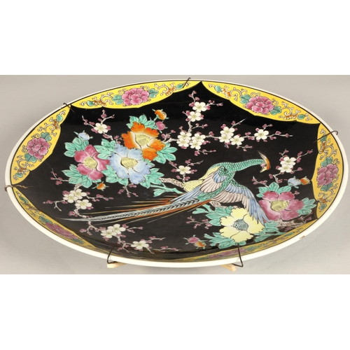 214 - Japanese porcelain charger, black ground with bird and foliate decoration, 46cm diameter.