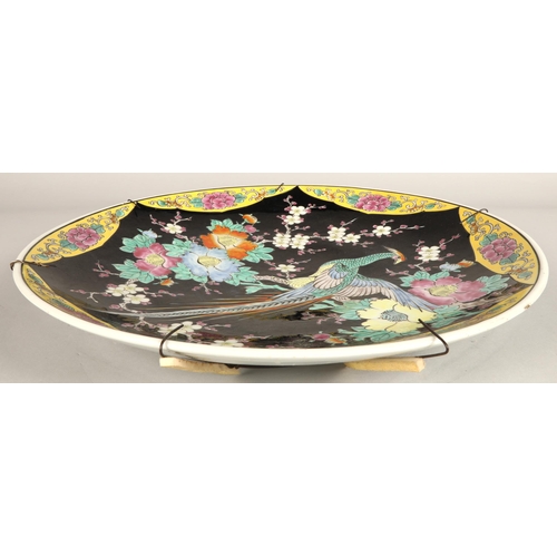 214 - Japanese porcelain charger, black ground with bird and foliate decoration, 46cm diameter.