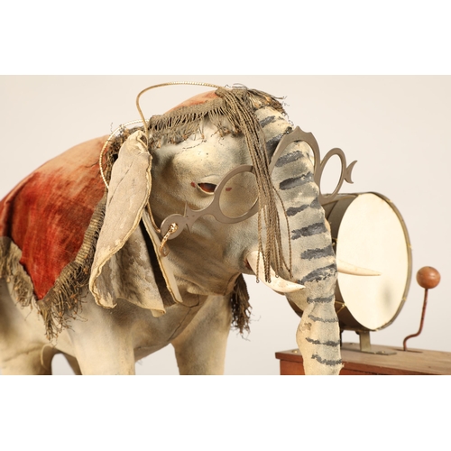 270 - An automaton figure of an elephant mounted on a wooden base, peering at the music on a stand through... 