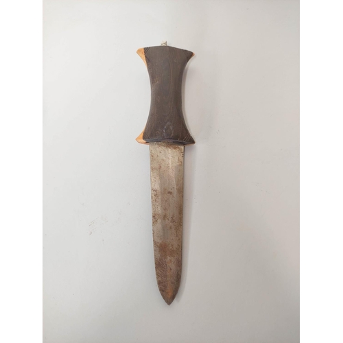 346 - A Sudanese arm knife with tapering straight blade and carved wooden hilt. Contained in tooled leathe... 