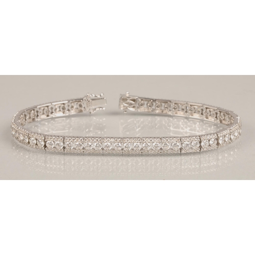 73 - Ladies 18k white gold diamond tennis bracelet, 56 small brilliant cut diamonds with a row of smaller... 