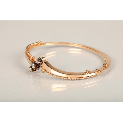 142 - Yellow metal and three stone diamond bangle, the hinged bangle with twisted wirework frame set with ... 