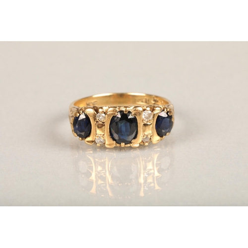 144 - Early 20th century 18ct gold three stone sapphire and diamond ring, the oval sapphires interspaced w... 