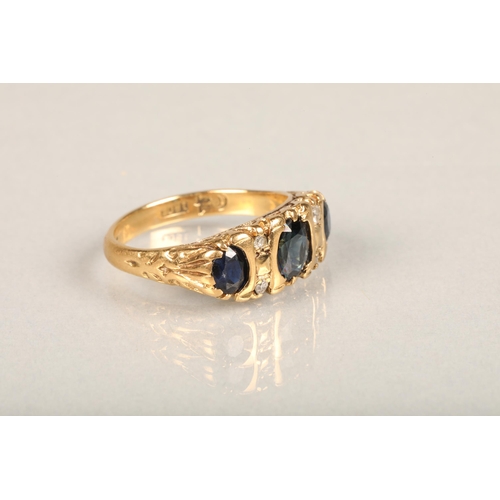 144 - Early 20th century 18ct gold three stone sapphire and diamond ring, the oval sapphires interspaced w... 