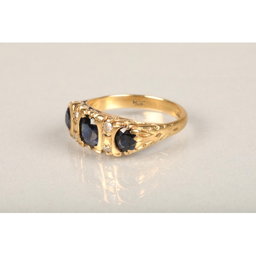 144 - Early 20th century 18ct gold three stone sapphire and diamond ring, the oval sapphires interspaced w... 