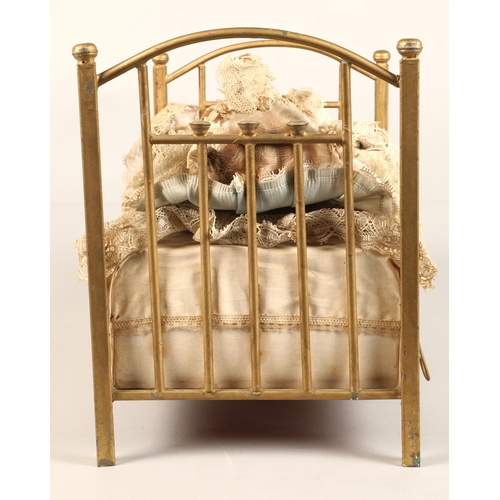 269 - A 19th century musical automaton in the form of a Victorian doll lying in a brass bedstead and holdi... 