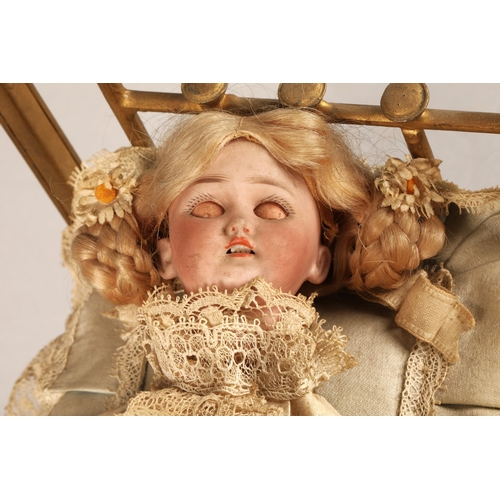 269 - A 19th century musical automaton in the form of a Victorian doll lying in a brass bedstead and holdi... 