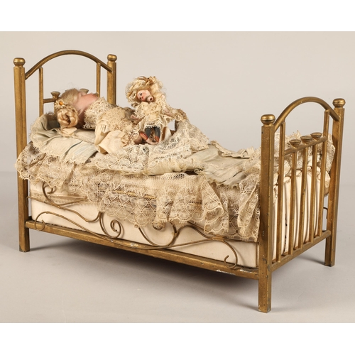 269 - A 19th century musical automaton in the form of a Victorian doll lying in a brass bedstead and holdi... 