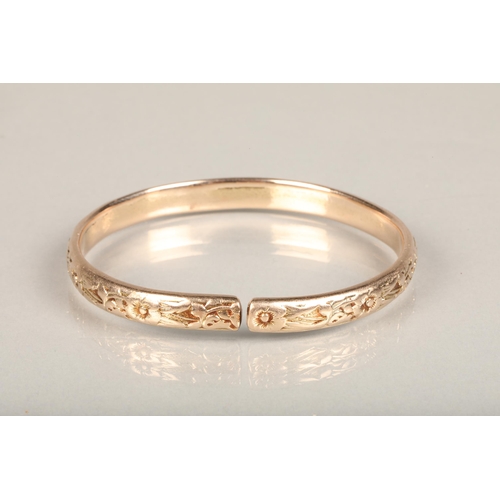 178 - Rose gold coloured yellow metal West Indian bayras bangle with floral pattern, unhallmaked but typic... 