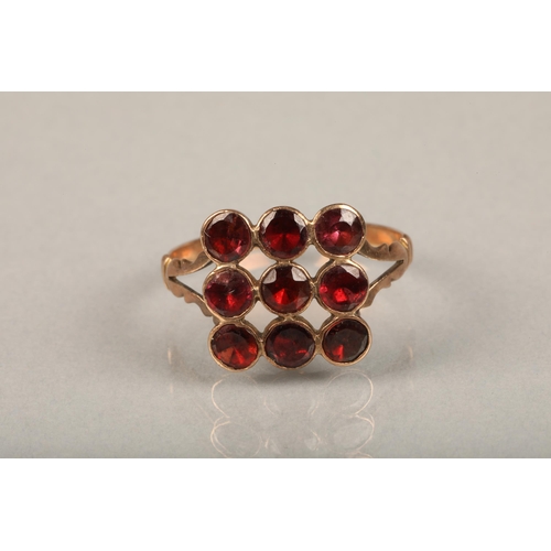 235 - Edwardian garnet and yellow metal ring, the nine round cut garnets in grid shape on split shoulders ... 