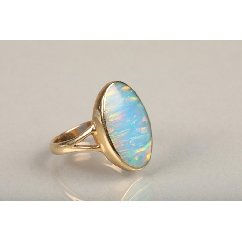 247 - 9ct gold and opal ring, the oval opal bezel set in gold frame leading to split shoulders on a plain ... 