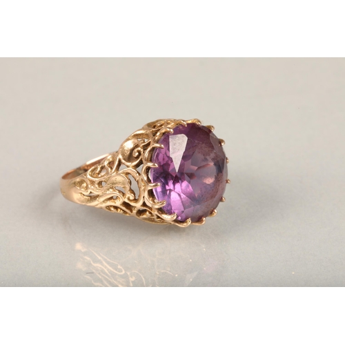 248 - Yellow gold and large amethyst ring, the round cut amethyst claw set on a repeating scroll pattern o... 