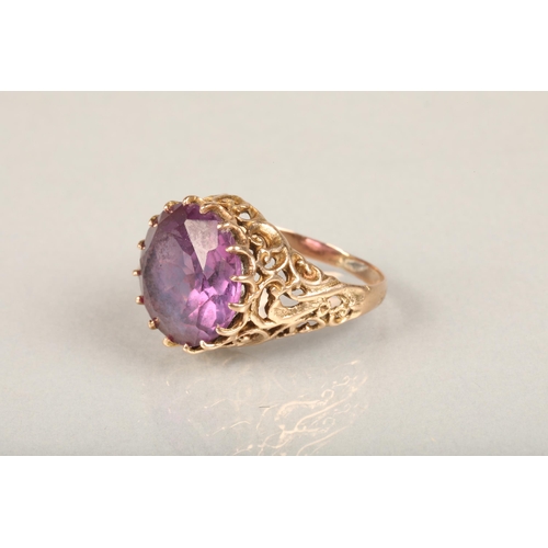 248 - Yellow gold and large amethyst ring, the round cut amethyst claw set on a repeating scroll pattern o... 