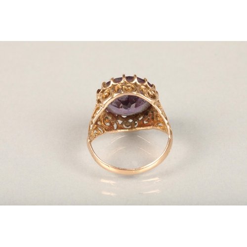 248 - Yellow gold and large amethyst ring, the round cut amethyst claw set on a repeating scroll pattern o... 