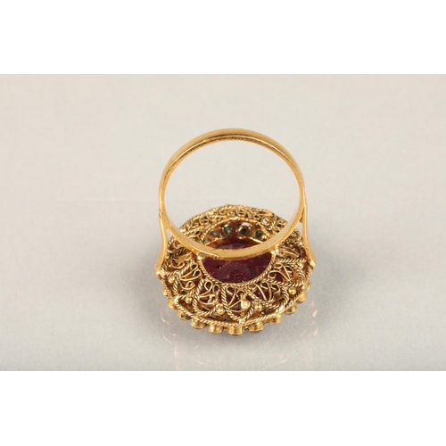 252 - Indian ruby, emerald and white stone cluster cocktail ring (tests as gold), the large oval facet cut... 