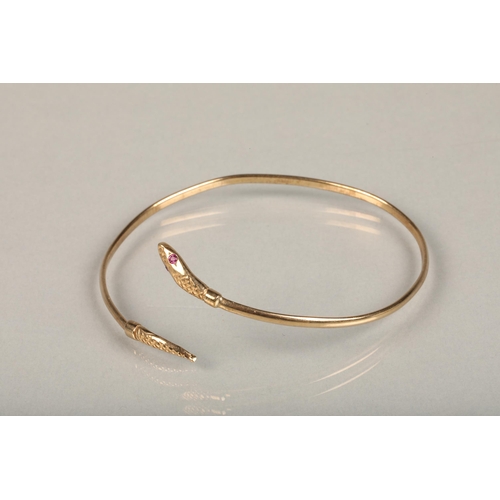 253 - 9ct gold filled snake bangle, the snake head with pink gem set eyes, internal W6.5cm, gross 4.4g.