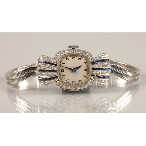 114 - Ladies platinum and sapphire cocktail watch, numbered dial surrounded by small diamonds, with four v... 