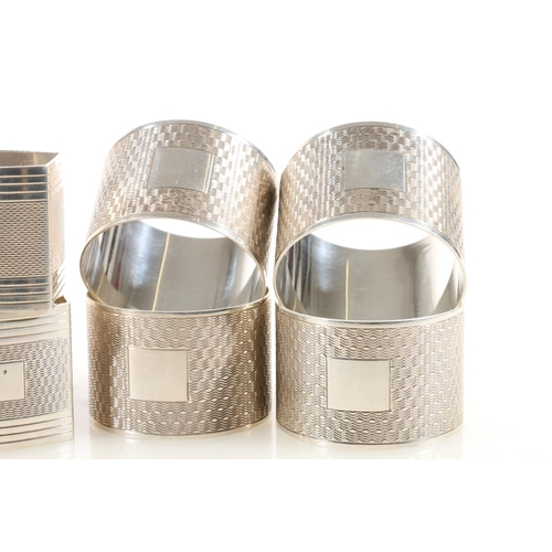 48 - Set of ten George V silver napkin rings, the round bodies with engine-turned decoration and square c... 