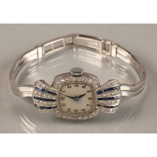 114 - Ladies platinum and sapphire cocktail watch, numbered dial surrounded by small diamonds, with four v... 