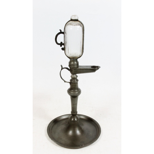 381 - Continental pewter whale oil lamp clock, 19th century, the glass reservoir enclosed within pewter ho... 