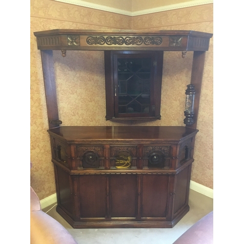 618 - 20th century carved oak corner bar unit with five panel front, the lower frieze with bullseye and pl... 