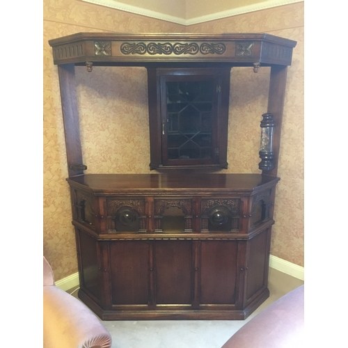 618 - 20th century carved oak corner bar unit with five panel front, the lower frieze with bullseye and pl... 