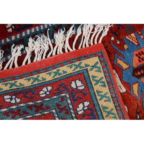 627 - Turkish wool runner, the geometric motifs on red ground within polychrome borders, 298cm x 82cm.