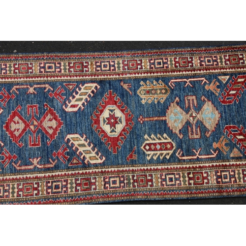 628 - Caucasian style runner, the geometric designs on a blue ground within conforming polychrome border, ... 