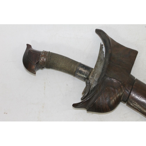 1554 - Malaysian kris with typical ornate flamberge blade, white metal wire bound grip and treen birds head... 