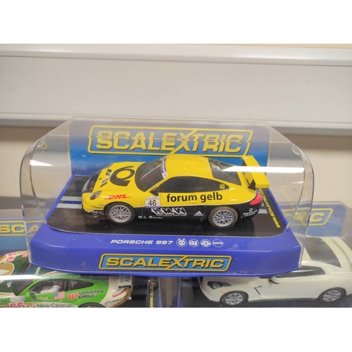 124 - Scalextric. Five 1/32 scale racing car models in perspex cases to include Porsche 997 C3079, Nissan ... 