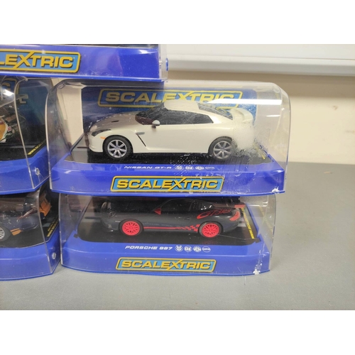 124 - Scalextric. Five 1/32 scale racing car models in perspex cases to include Porsche 997 C3079, Nissan ... 