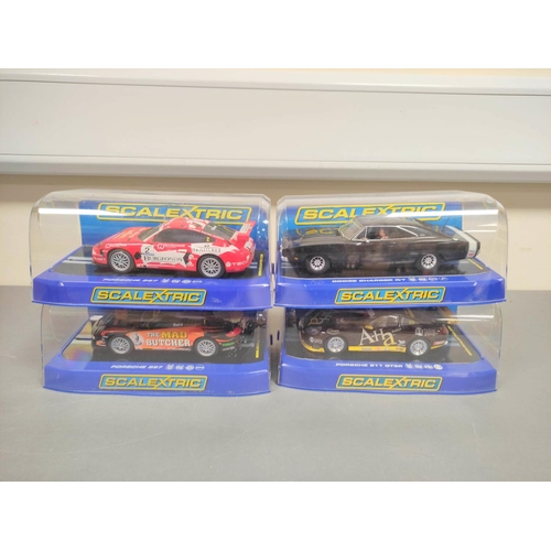 125 - Scalextric. Four 1/32 scale racing car models in perspex cases to include a Porsche 997 C2899, a Por... 