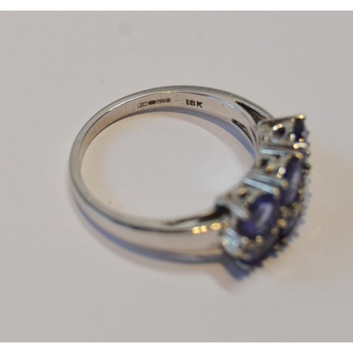 83 - Tanzanite six-stone ring with tiny diamond brilliants, in 18ct white gold, size O½, 5.1g gross.