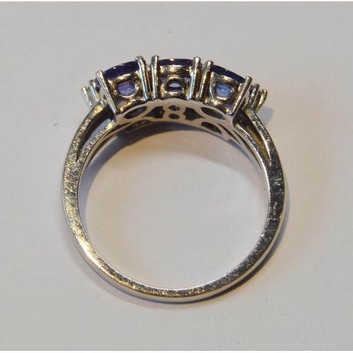 83 - Tanzanite six-stone ring with tiny diamond brilliants, in 18ct white gold, size O½, 5.1g gross.