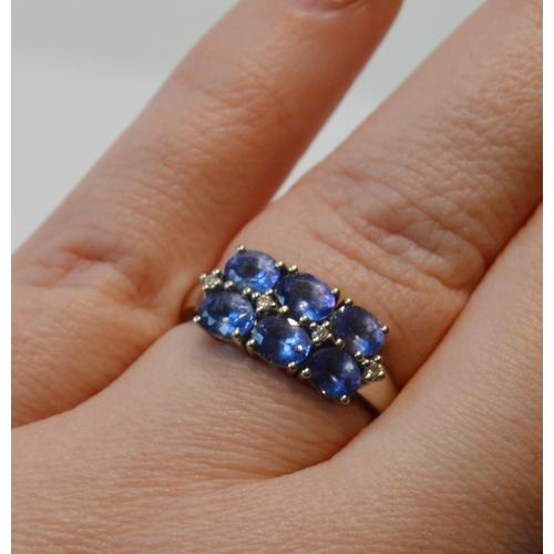 83 - Tanzanite six-stone ring with tiny diamond brilliants, in 18ct white gold, size O½, 5.1g gross.