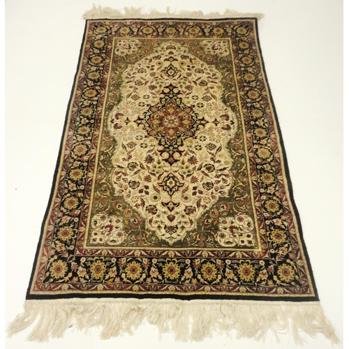 384 - Kashmir silk rug with foliate medallion to the centre, on cream, red and blue field within all over ... 