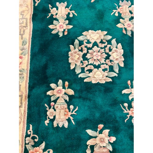 Oriental style rug on emerald green ground 187cm x 124cm
