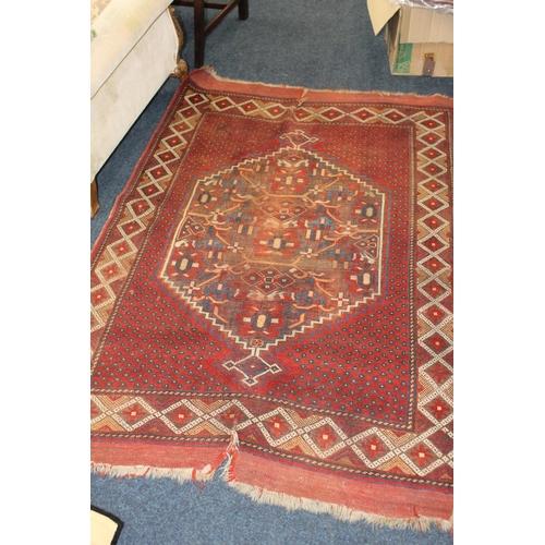 695 - Caucasian rug with central geometric motifs on a rust red ground, 178cm x 125cm.