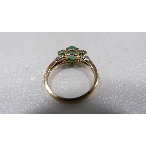 240 - 9ct gold emerald-coloured three-stone ring set with brilliant-cut diamonds to the shoulders, 2.1g gr... 