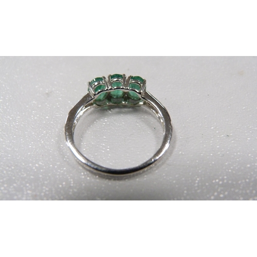 241 - 9ct white gold emerald-coloured three-stone lady's ring set with diamonds to the shoulders, 2.2g gro... 