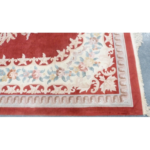 316 - Large Chinese-style carpet on red and cream ground.